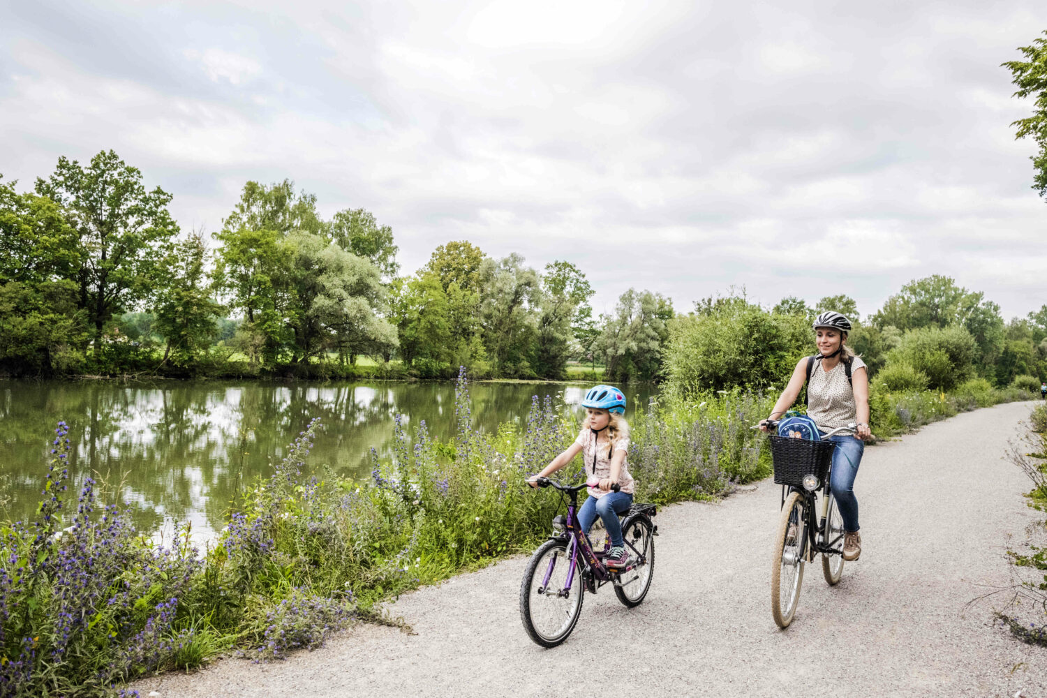 Mutter und Tochter beim Radfahren in einer Flusslandschaft