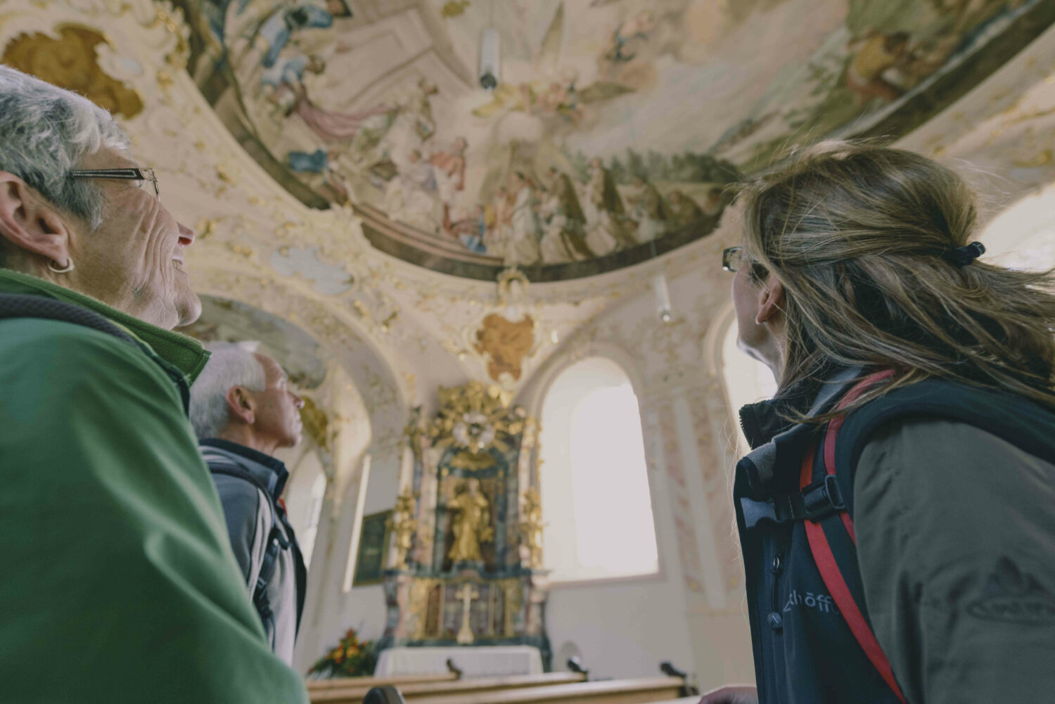 Blick in die Gnadenkapelle Hohenpeißenberg: 3 Besucher bewundern das Deckenfresko. Im Hintergrund der Altar.